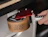 A hand using a tape dispenser with printed brown paper tape featuring the 'RUSH COFFEE ROASTERS' logo