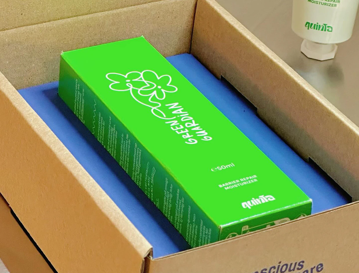 A bright green Quinta product box with floral graphics resting inside a shipping package