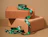 A roll of green satin ribbon printed with white Christmas tree patterns draped over stacked cardboard gift boxes