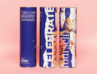 Three tall navy paper cans with bold full-colour prints on a pink background