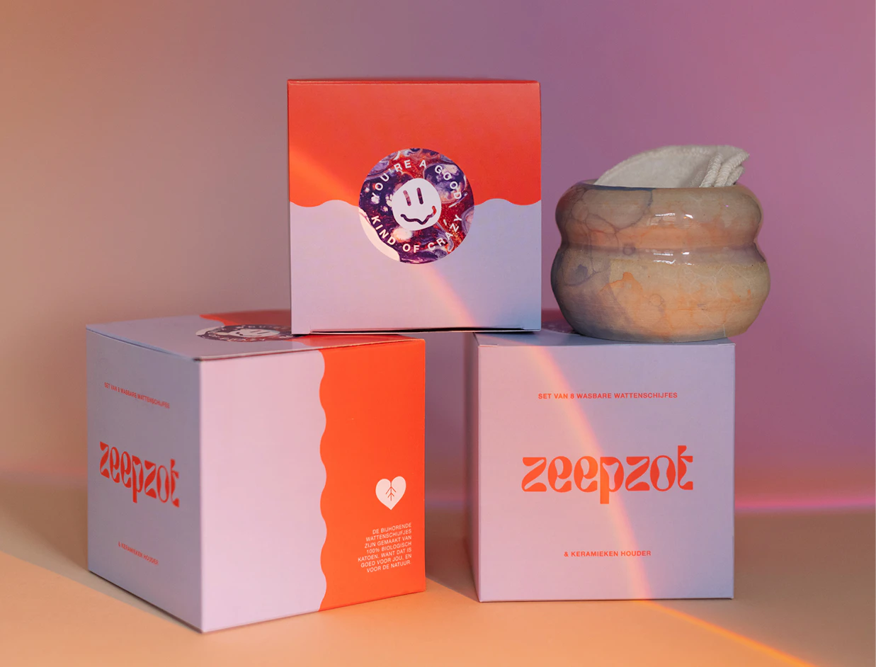 Three pastel purple and orange product boxes with the brand name 'zeepzot', paired with a ceramic holder filled with reusable cotton pads