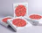Multiple white pizza boxes stacked together, decorated with a red central circle and black typography repeating the word 'PIZZA'