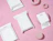 Flat lay of several blank white bubble mailers with die-cut handle cutouts arranged with pink geometric props on a pink background