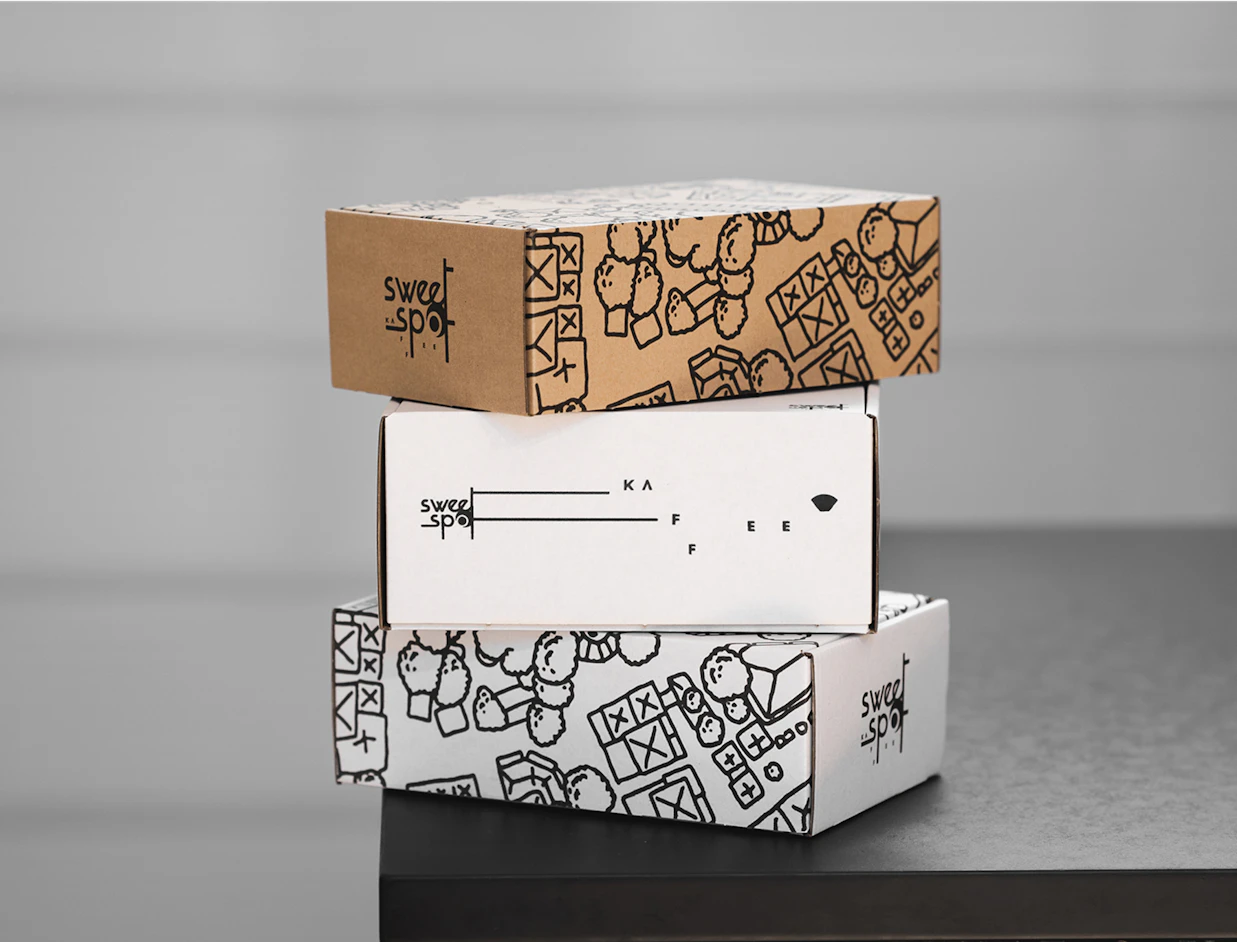 Three stacked eco mailer boxes in kraft and white cardboard, each with a one-colour black print