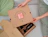 Hands unboxing a cardboard set with two glass spray bottles and a small pink Släppa box attached to the divider