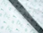 Close-up of white tissue paper with a green repeat pattern of icons and script lettering