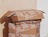 Stack of kraft mailer boxes with an all-over white text print, the top box open