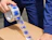 A worker taping a cardboard box with transparent tape featuring blue abstract icons
