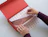 Hands carefully folding patterned tissue paper printed with pink star symbols over a garment in a red gift box