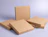 Multiple plain brown kraft cardboard pizza boxes stacked together against a light purple background