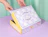 Hands opening a lilac and white checkered full colour mailer box with playful graphics