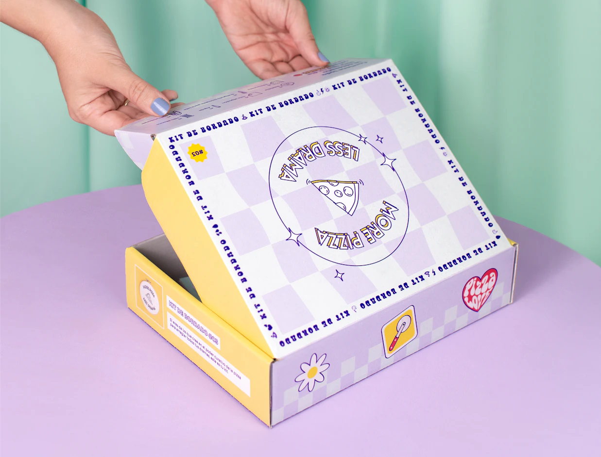 Hands opening a lilac and white checkered full colour mailer box with playful graphics