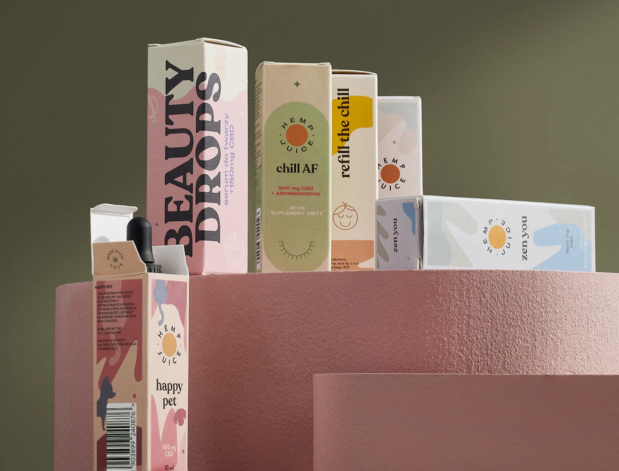 Collection of pastel Hemp Juice CBD oil boxes arranged on pink geometric display stands