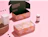Open full colour mailer boxes with a pink floral print inside and out, beside cosmetics jars