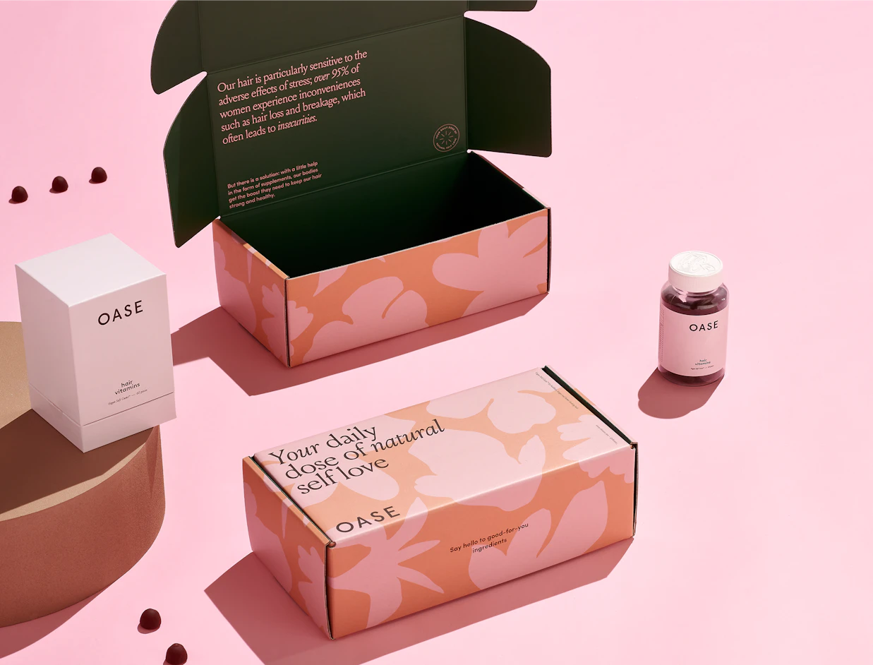 Open full colour mailer boxes with a pink floral print inside and out, beside cosmetics jars