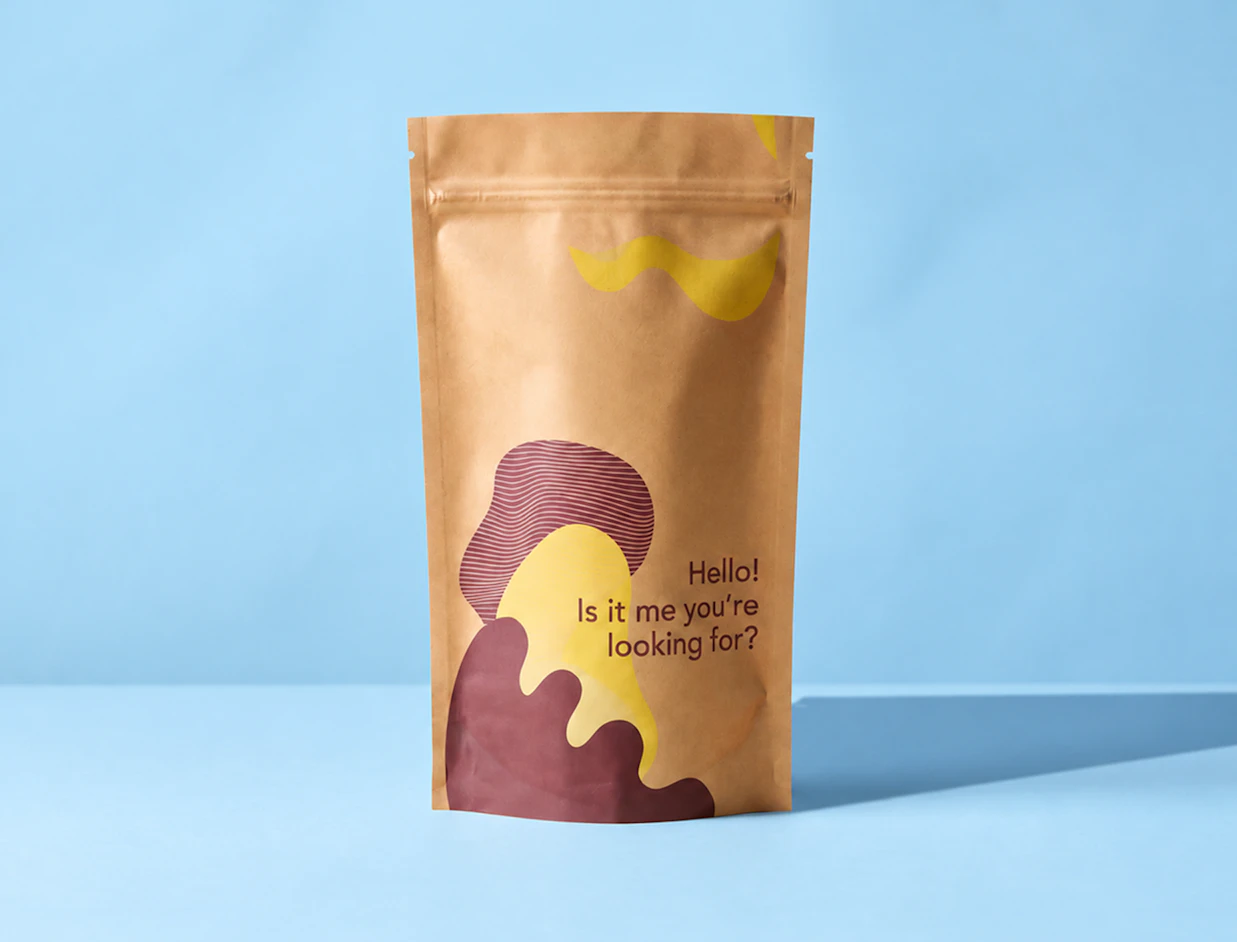 A kraft paper ziplock pouch printed with yellow and burgundy abstract graphics and 'Hello! Is it me you're looking for?' against a light blue background