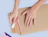 Top-down view of hands peeling the adhesive backing off a kraft cardboard envelope to seal it