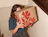 Person holding a kraft eco mailer box with a large one-colour red floral print