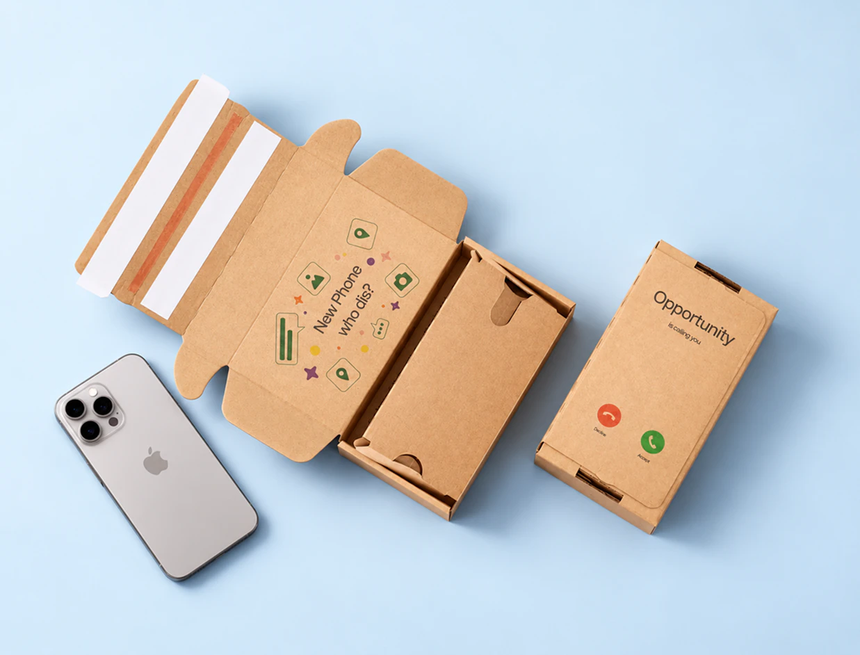 An open kraft cardboard phone mailer box printed with 'New Phone who dis?' lying next to a silver smartphone and a closed box reading 'Opportunity is calling you'