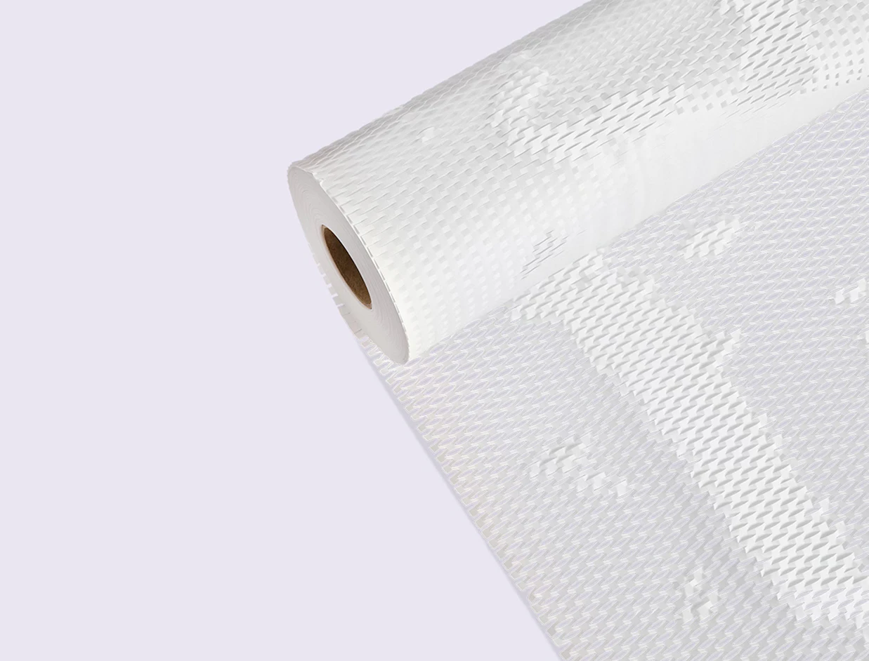 A large roll of white honeycomb paper wrap used for eco-friendly product packaging