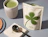 An open cream-colored stand-up pouch labeled 'luma COFFEE' next to a cup of matcha latte and a metal scoop
