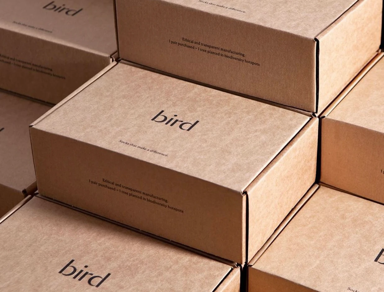 Rows of kraft eco mailer boxes with a minimal one-colour black logo print