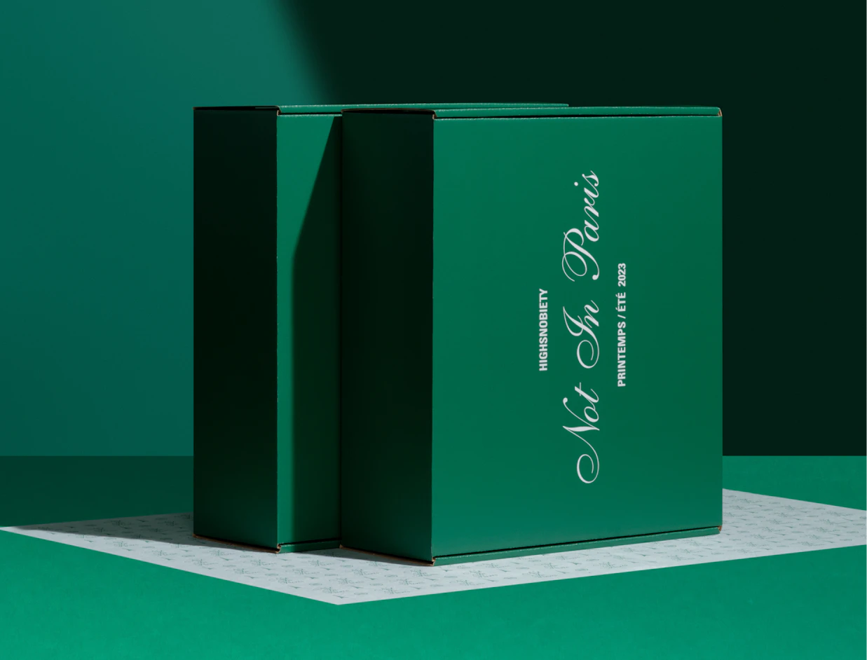 Dark green full colour mailer boxes with white script lettering on a green backdrop