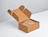 An open kraft cardboard mailer box containing a brown burlap drawstring bag on a white surface