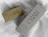 Two printed product boxes in olive and grey with black lettering on white fabric