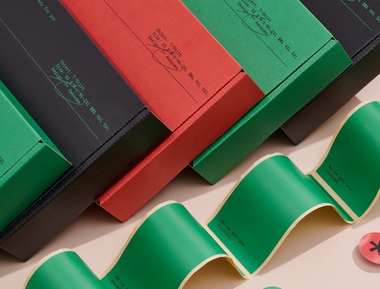 Row of eco colour mailer boxes in black, red and green with printed lettering