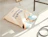 Natural cotton tote bag with a navy text print lying on the floor with sneakers inside