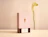 Two sliding drawer candle boxes branded 'Maison Solenne' displaying glass candle jars decorated with gold dots against a pink backdrop