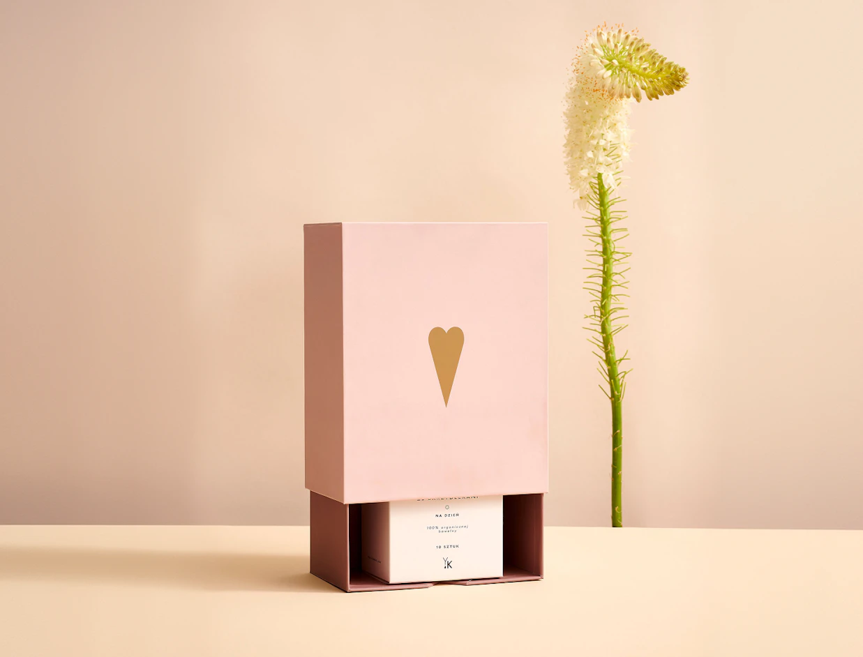 Two sliding drawer candle boxes branded 'Maison Solenne' displaying glass candle jars decorated with gold dots against a pink backdrop