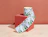A roll of custom labels with abstract green and blue patterns unrolling over a red cube