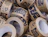 Close-up pile of brown paper tape rolls printed with 'HANDLE WITH CARE' and recycling icons in dark ink