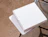 Top-down view of two plain white cardboard pizza boxes stacked on a outdoor metal mesh table