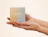 Two hands gently holding a small pastel gradient box printed with 'FILIPPA FIRENZE'