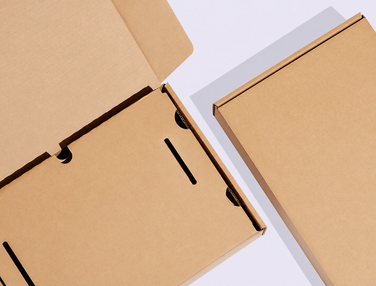 Top-down view of open and closed brown kraft laptop shipping boxes with internal cardboard stabilization inserts