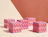 Five red and purple patterned square boxes labeled 'Orion' arranged on a light wood table