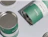 Close-up of green and white printed paper cans showing the metal rim