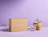 A cardboard box sealed with 'FRAGILE' paper tape surrounded by glass cups printed with red fox illustrations on a purple background