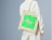 Person wearing a natural cotton tote bag with a bright green block print on the shoulder