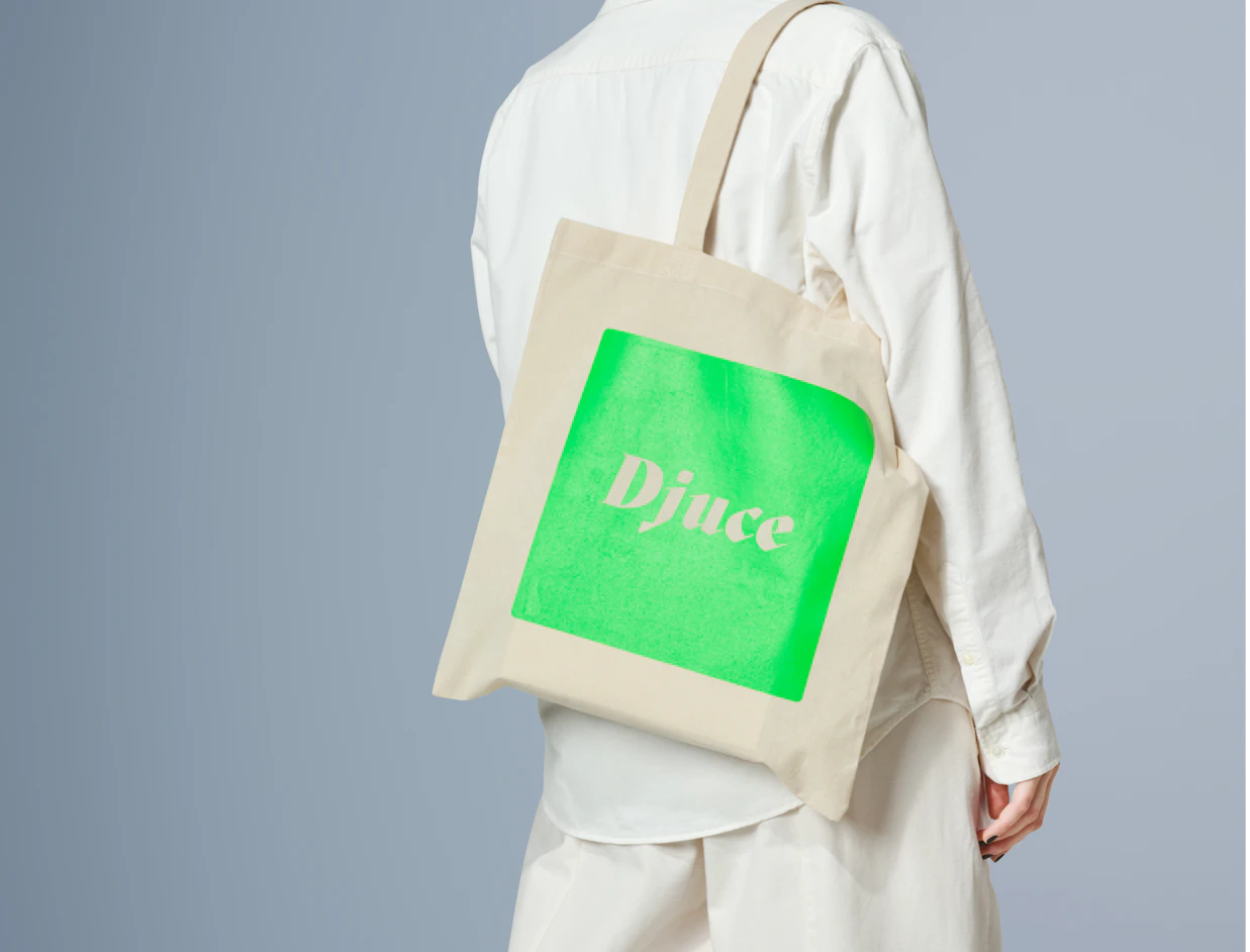 Person wearing a natural cotton tote bag with a bright green block print on the shoulder