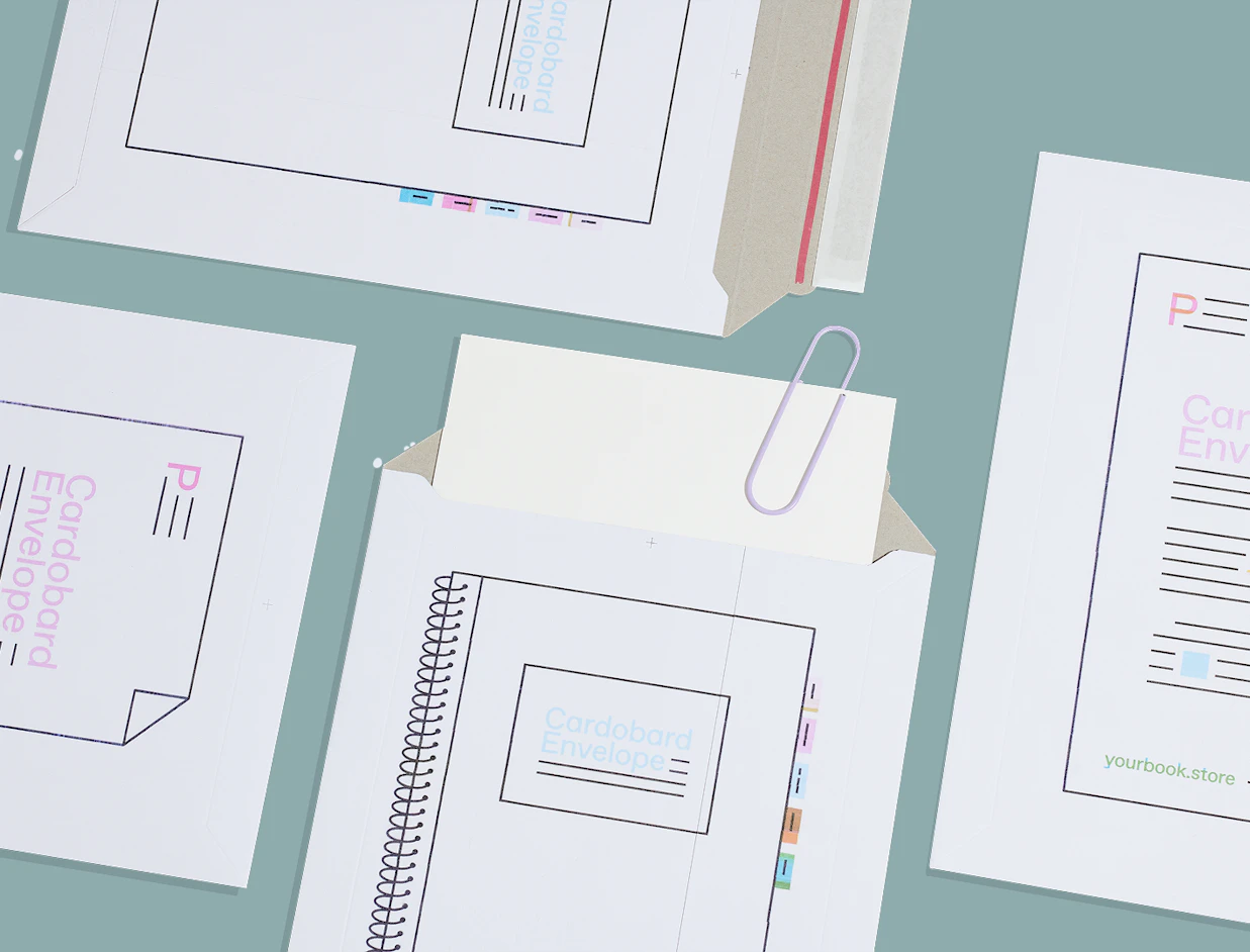 White cardboard mailer envelopes with notebook print details spread out on a light blue background