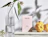 A light pink OASE hair vitamins box on a marble slab next to yellow quinces and a glass vase with leaves