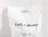 White bio poly mailer with a black logo print and die-cut handle against a panelled wall
