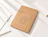 Kraft cardboard mailer envelope printed with 'Cardboard Envelope' document design, resting among white paper sheets
