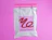 White poly mailer with a pink square logo for Thread Theory hanging on a pink hanger against a vibrant pink background