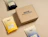 Kraft eco mailer box with a one-colour dark logo print on the lid, shown with coffee bags
