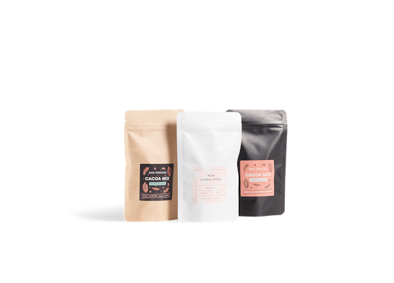 Three stand-up pouches with printing: one in kraft color, one white, and one black